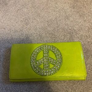 Light green wallet with ☮️ and sparkles on the front